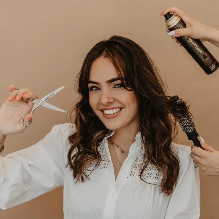 Veerle, eigenaar van Het Haaratelier VM, met een schaar en föhnborstel